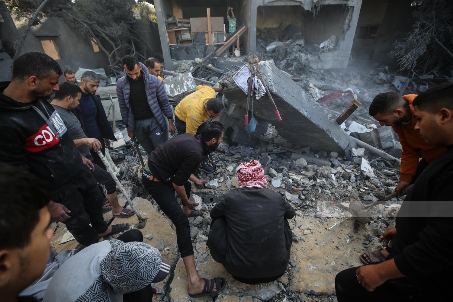 مواطنون يتفقدون الدمار بعد قصف طائرات الاحتلال الحربية منازل في مخيم البريج وسط قطاع غزة.